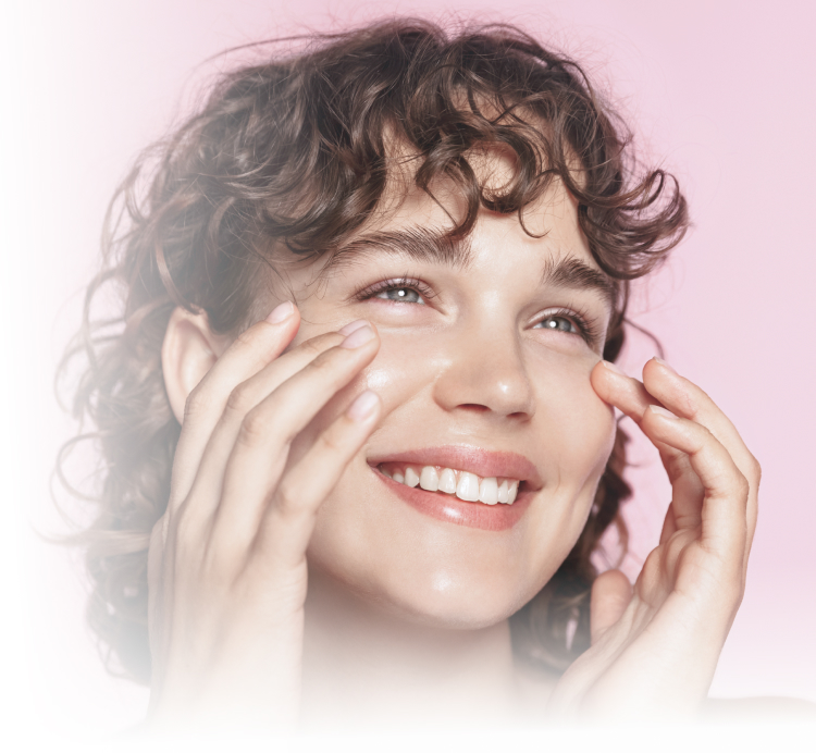 Jeune femme souriante qui se touche les joues avec ses mains chirurgie esthetique | Dr Souad Debache Evreux